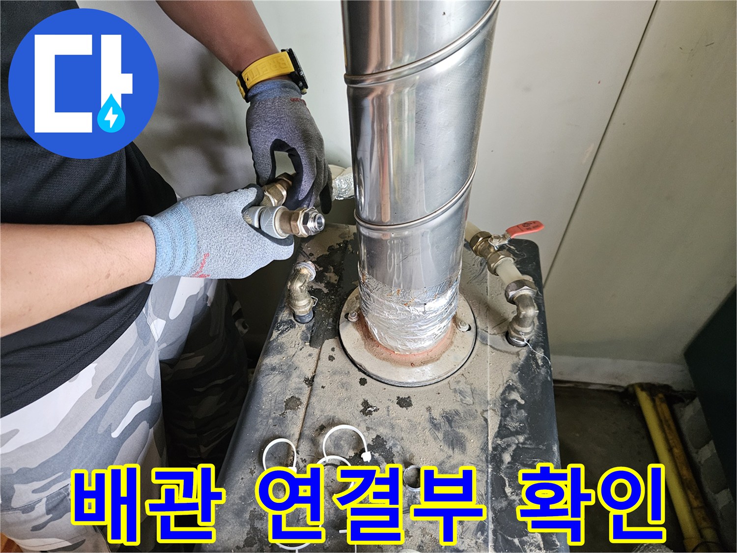 금속 연통 하단 배관 부위를 점검하는 작업자의 모습
