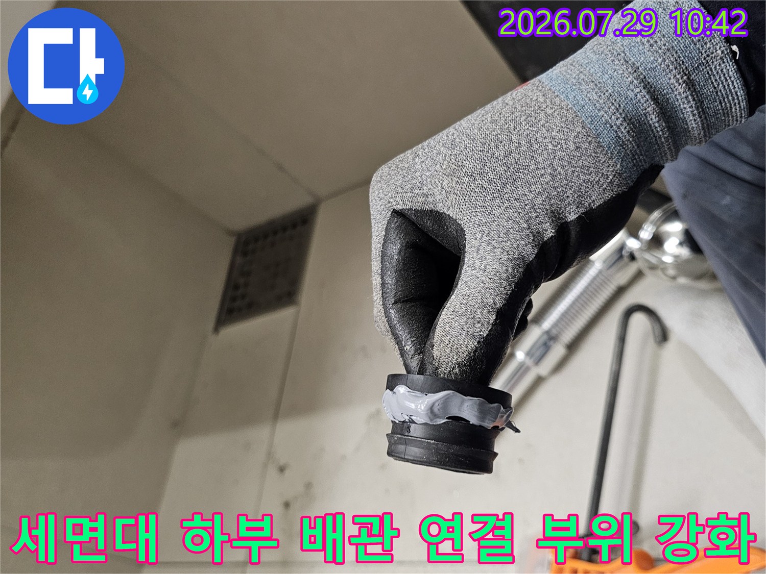 작업자가 세면대를 지탱하는 수직/수평 배수 구간의 결함부를 직접 점검 중인 모습