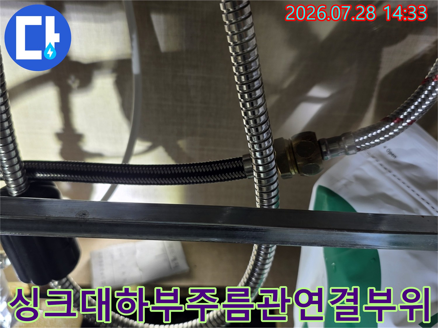 싱크대 하단-스테인리스 주름관 배관과 연결 너트 부근의 모습
