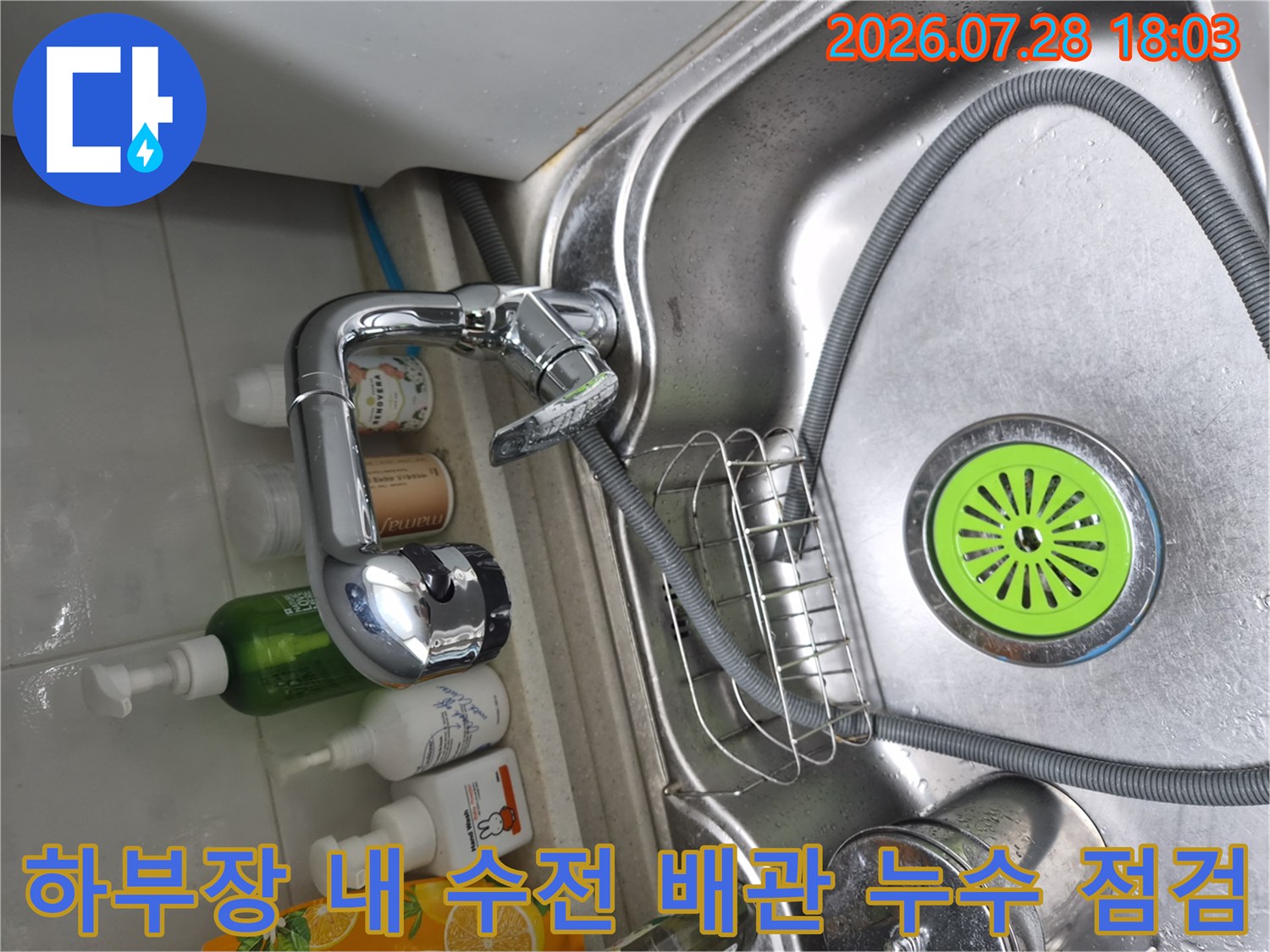 주방 하부장에서 식기세척기와 연결된 수도 배관의 결합 상태를 점검하는 모습