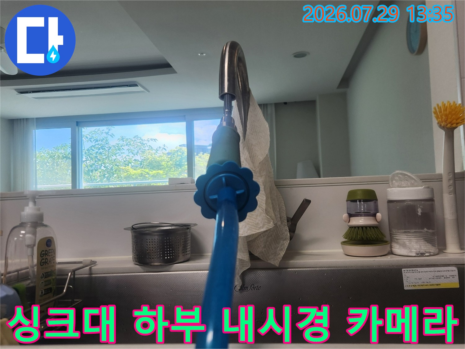 파란색 외관의 내시경 장비를 배수구에 연결하여 내부를 관찰하는 모습