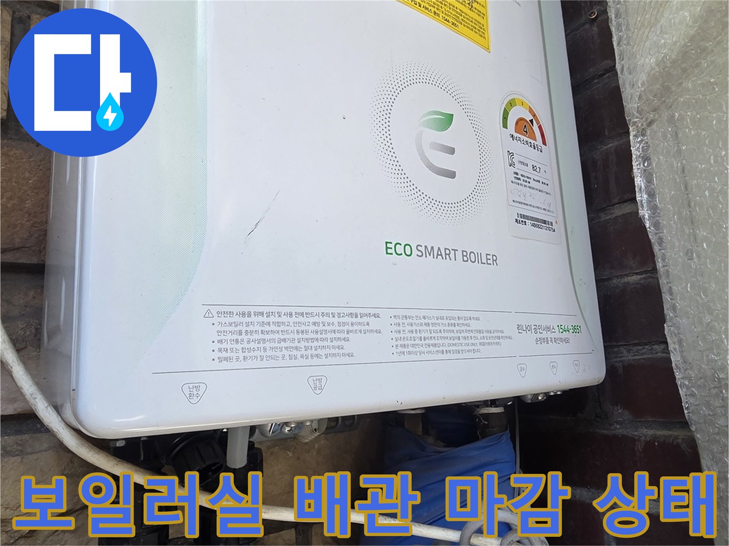 파란색 보온재가 씌워진 난방 배관과 은색 금속 밸브 부위