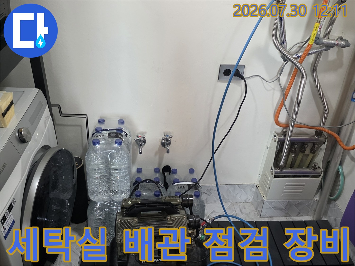 세탁실 공간에서 압력 게이지와 호스를 연결하여 배관 누수를 정밀하게 점검하는 모습