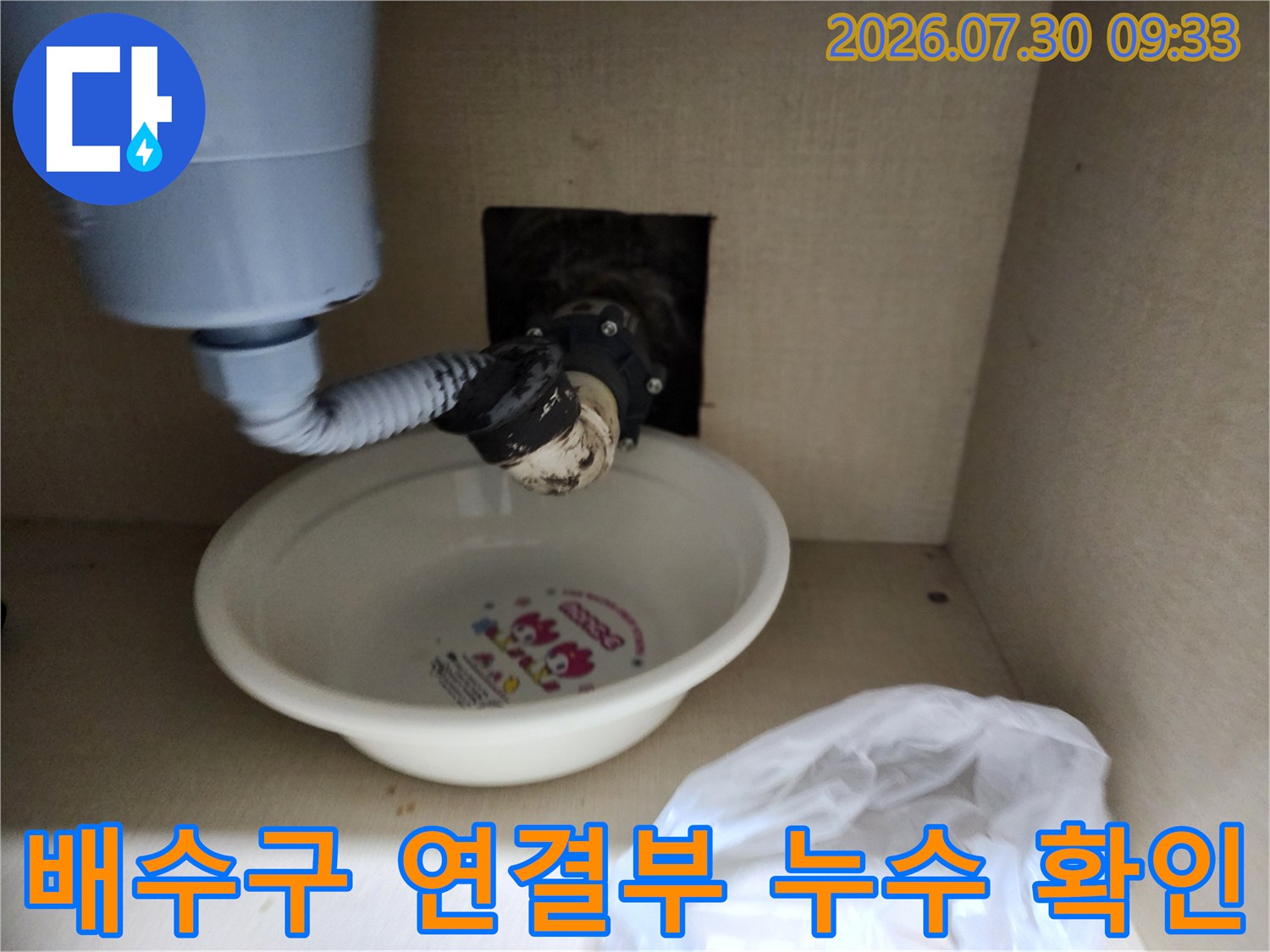 하수 배관과 싱크대 호스가 만나는 부위의 마감 상태를 점검하는 사진입니다.