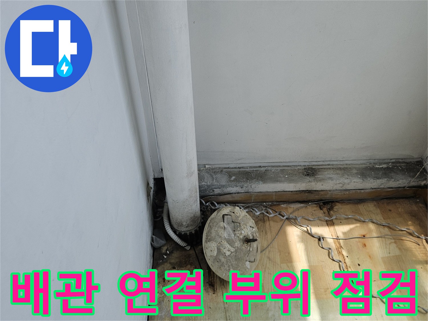 나무 벽면 근처에 노출된 흰색 배관과 연결 소켓 상태 확인