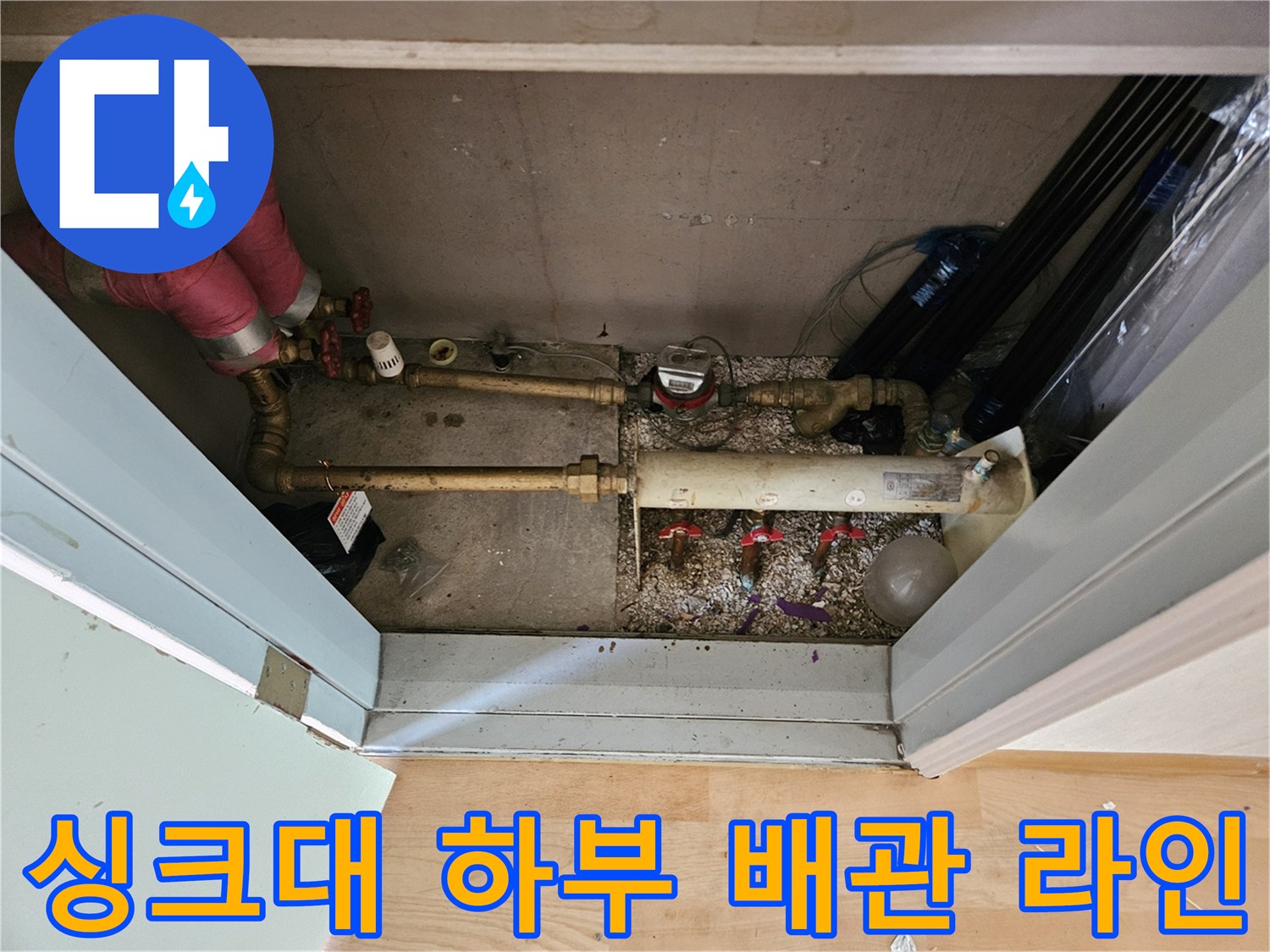 싱크대 밑바닥 공간에 설치된 금속 배관과 밸브 장치들