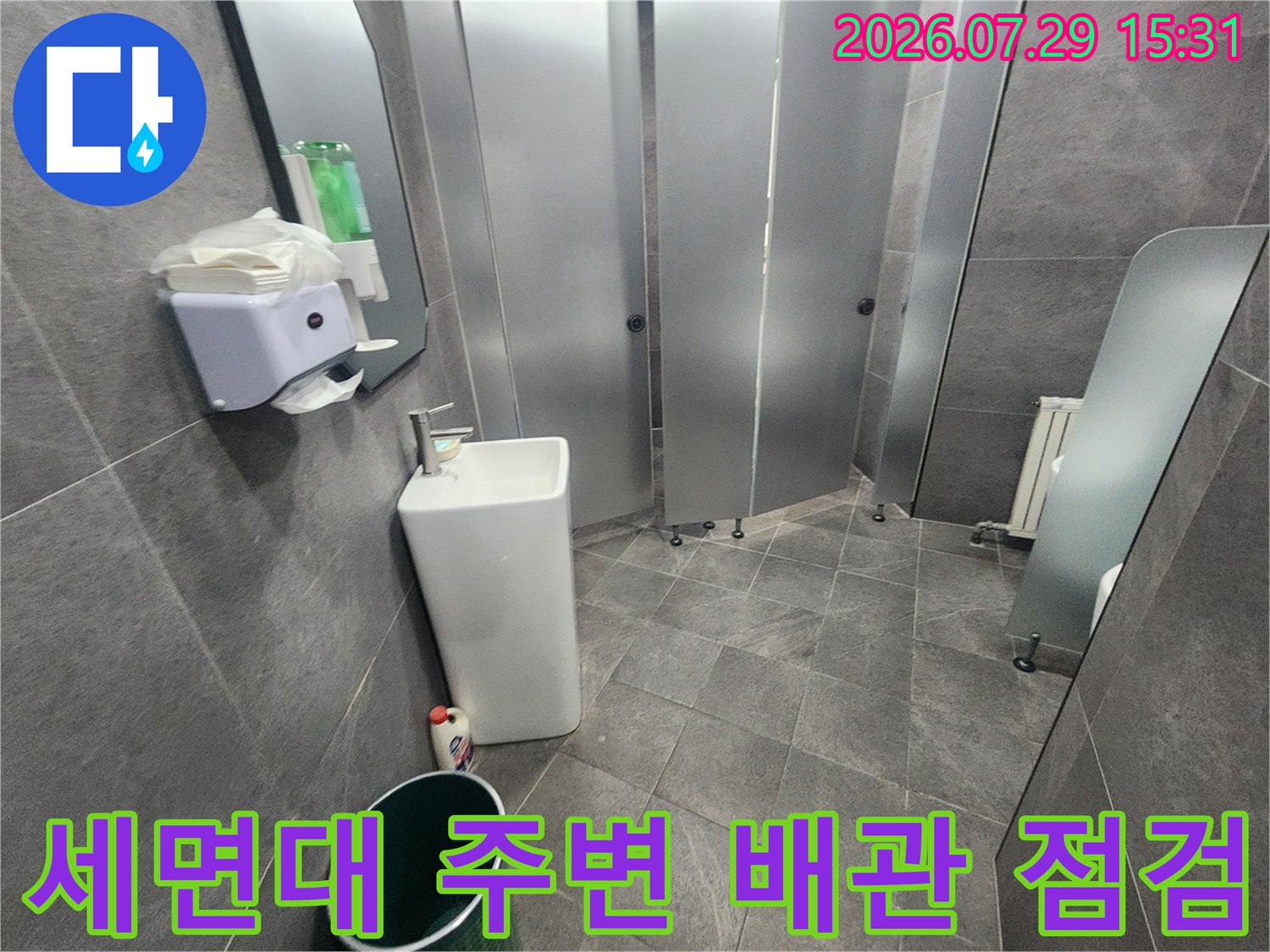 세면대 하부와 벽면 사이의 배관 연결 부위를 점검하는 기술자 시점