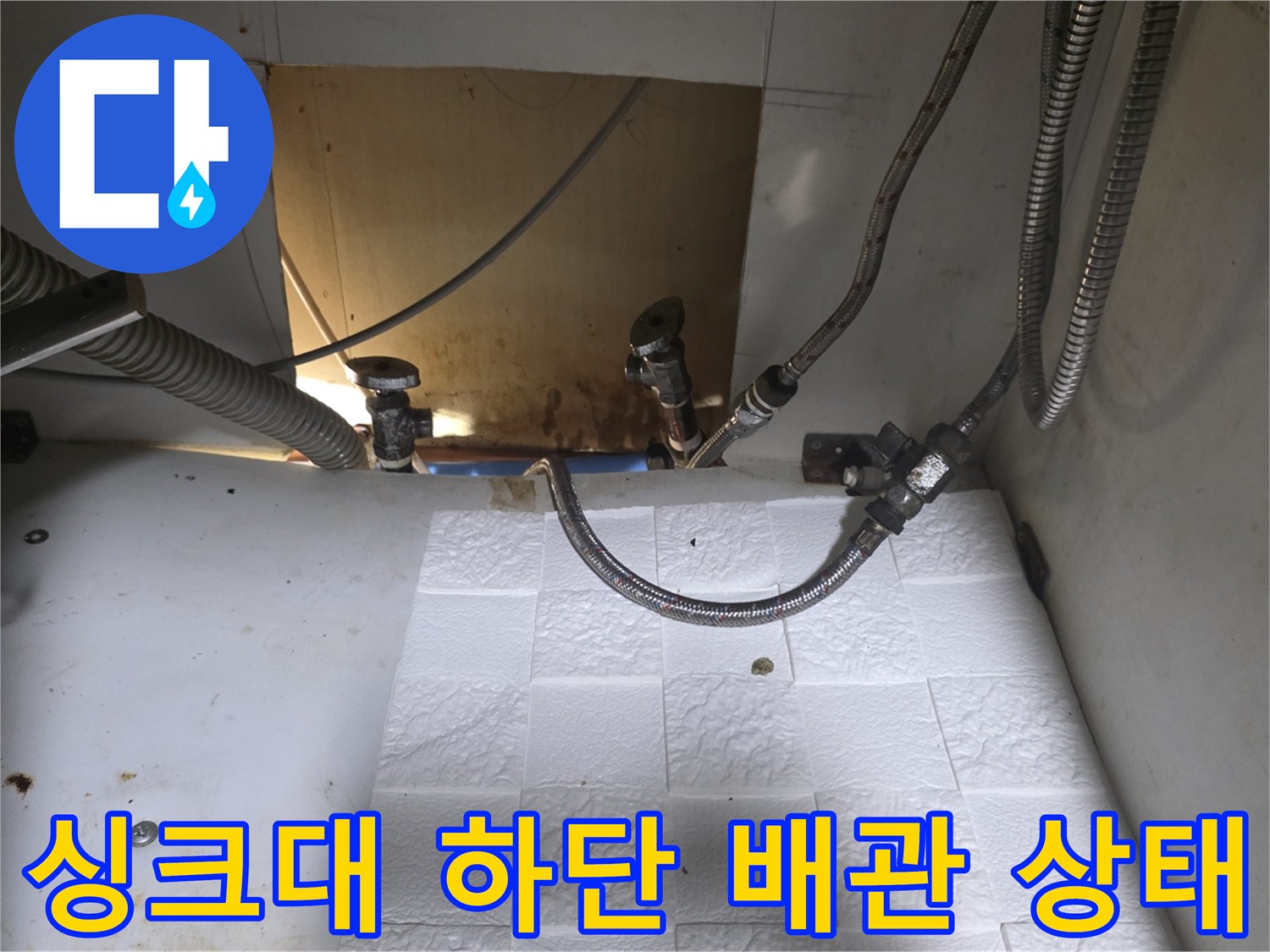 싱크대 하부장 내부의 노후된 배관과 연결 부위 모습입니다.