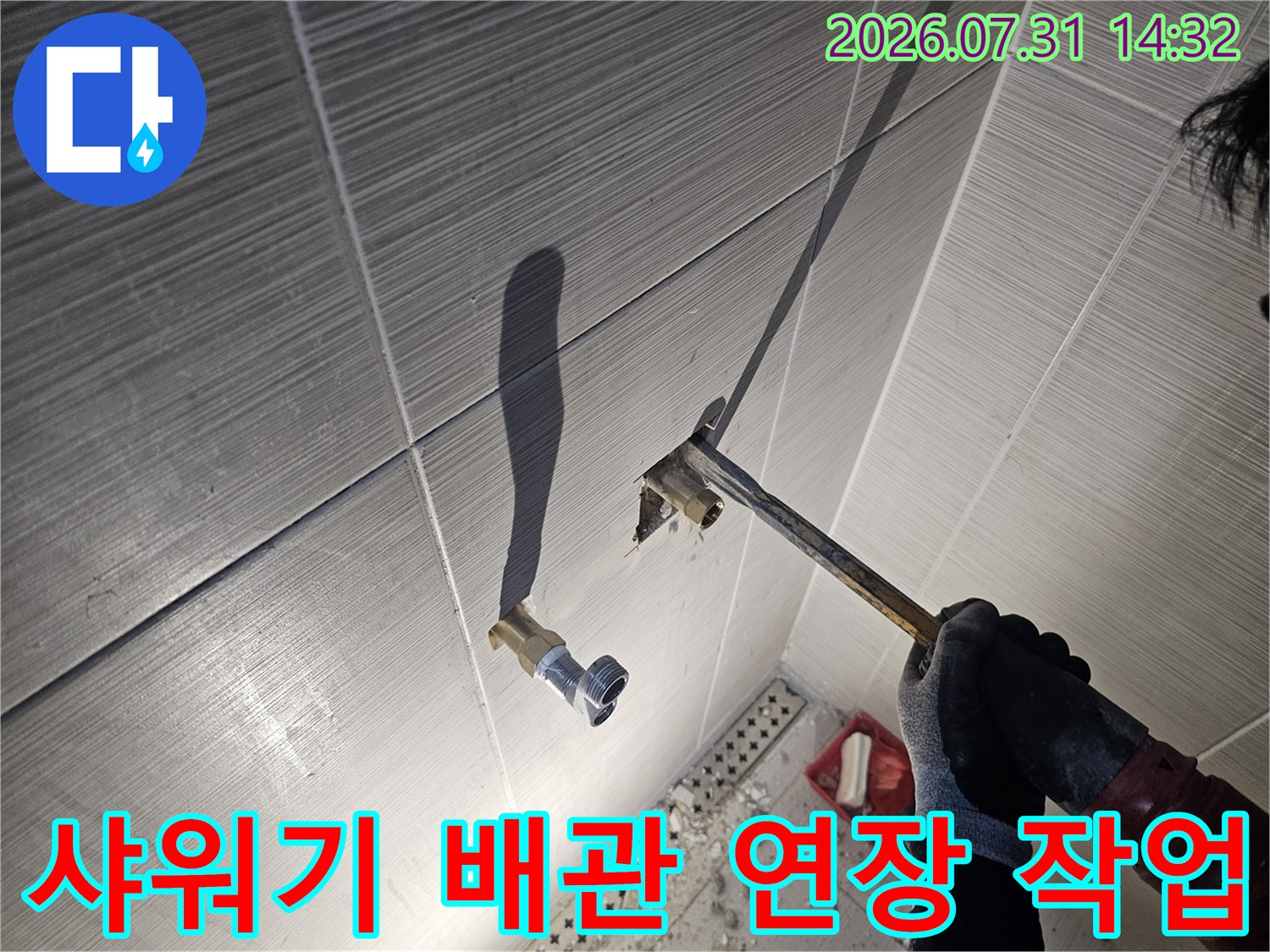 샤워용 수전 배관을 벽면에서 연장하여 연결하는 공사 현장 사진
