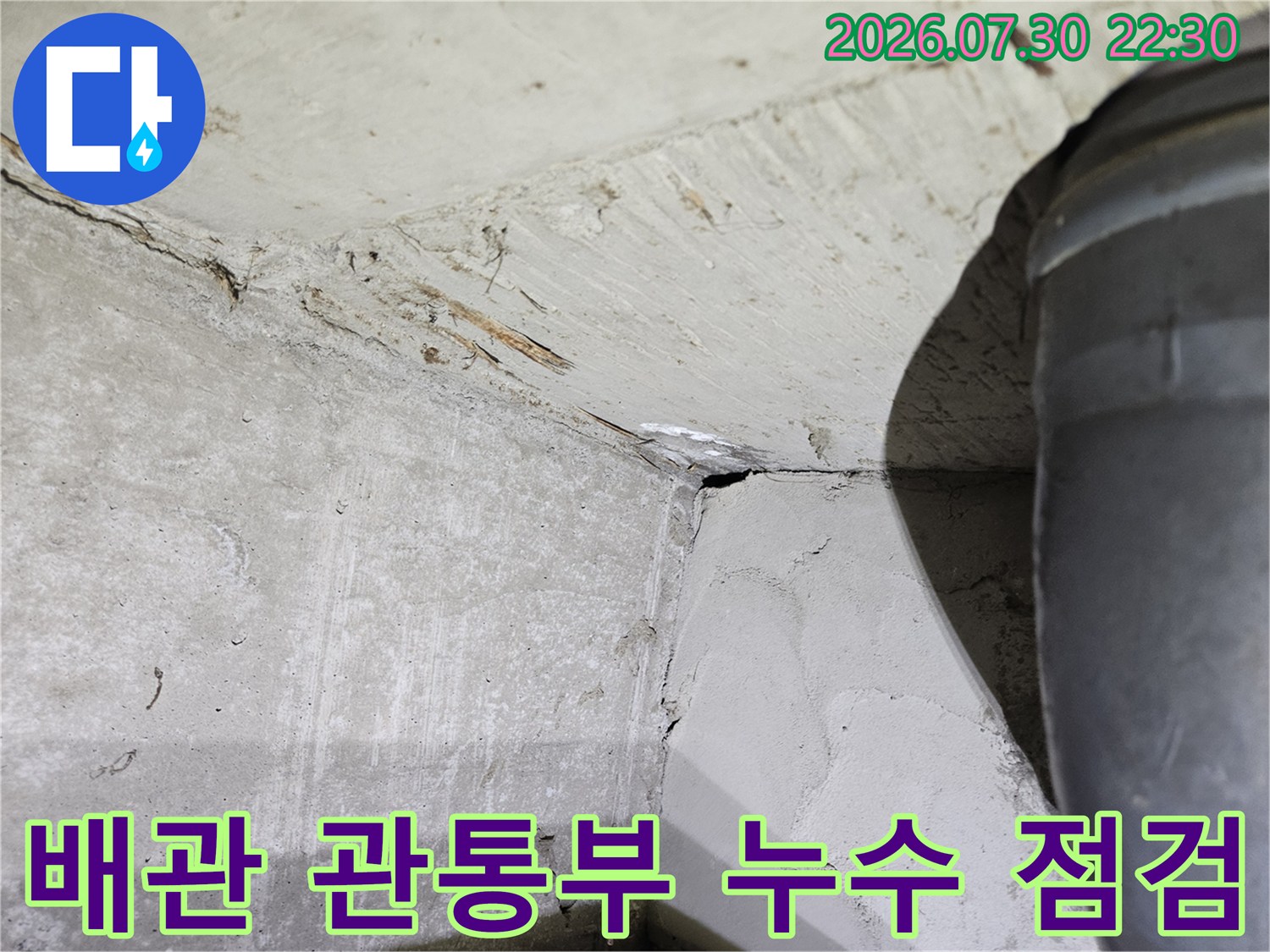 욕실 배출용 파이프와 주변 콘크리트 벽면의 상태를 촬영한 사진