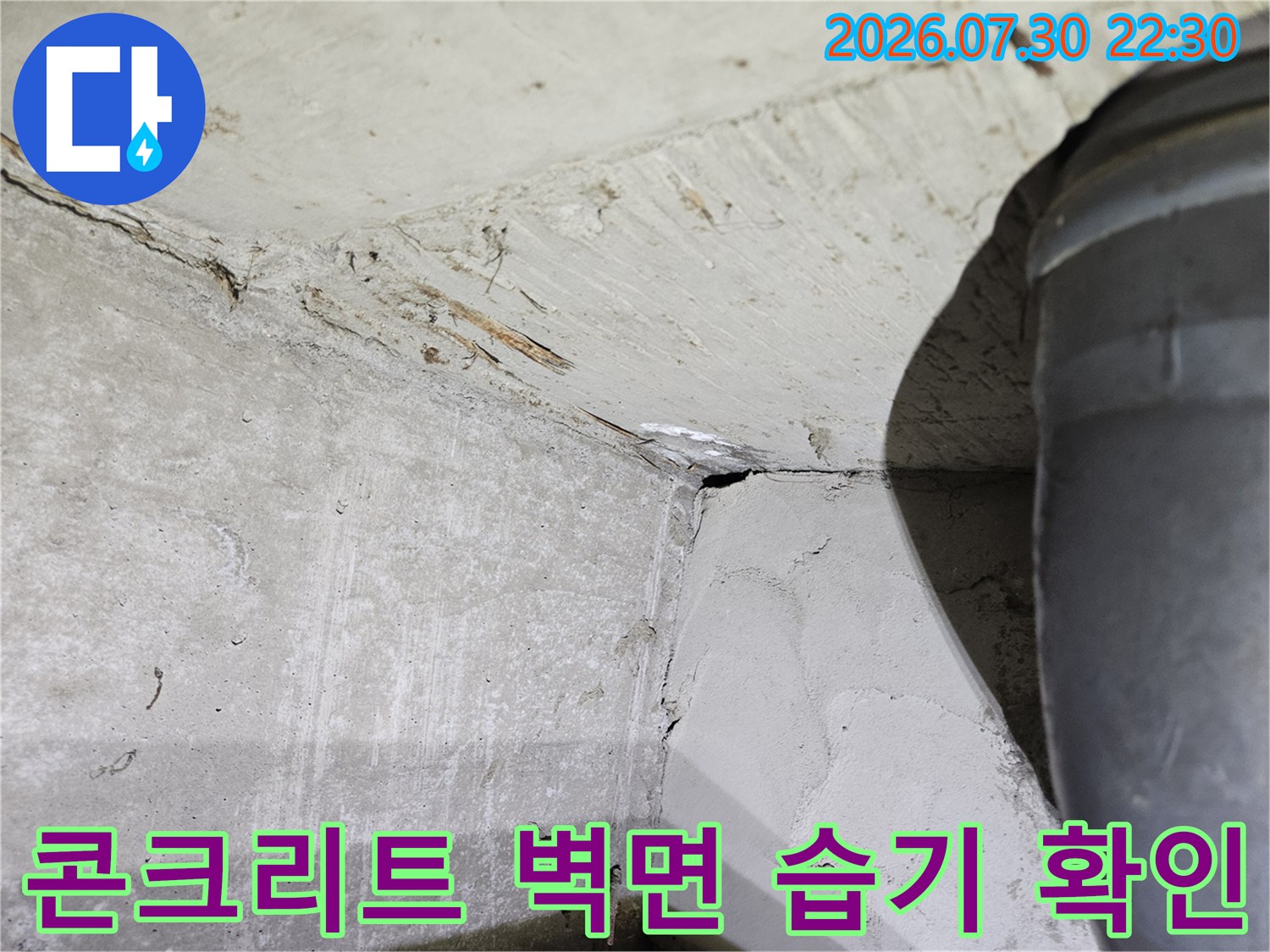 젖은 콘크리트 벽체와 배관 연결부의 노후 상태를 촬영한 사진