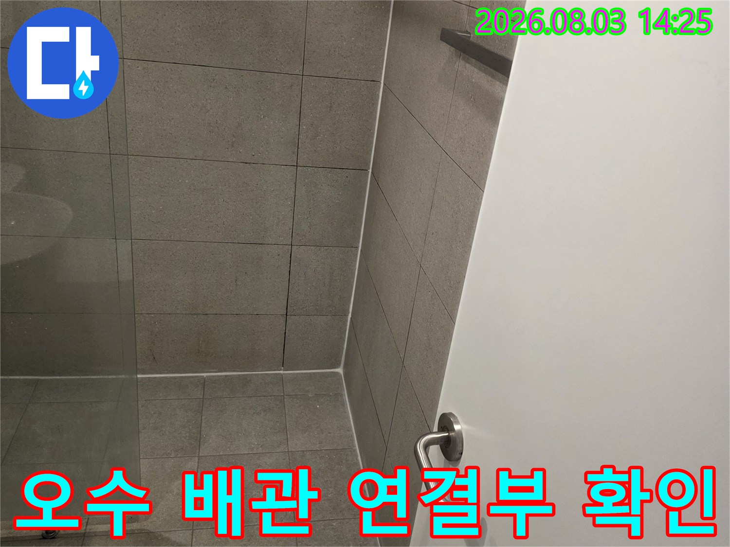 벽면과 천장 경계부에 설치된 오수 배관의 상태를 점검하는 장면