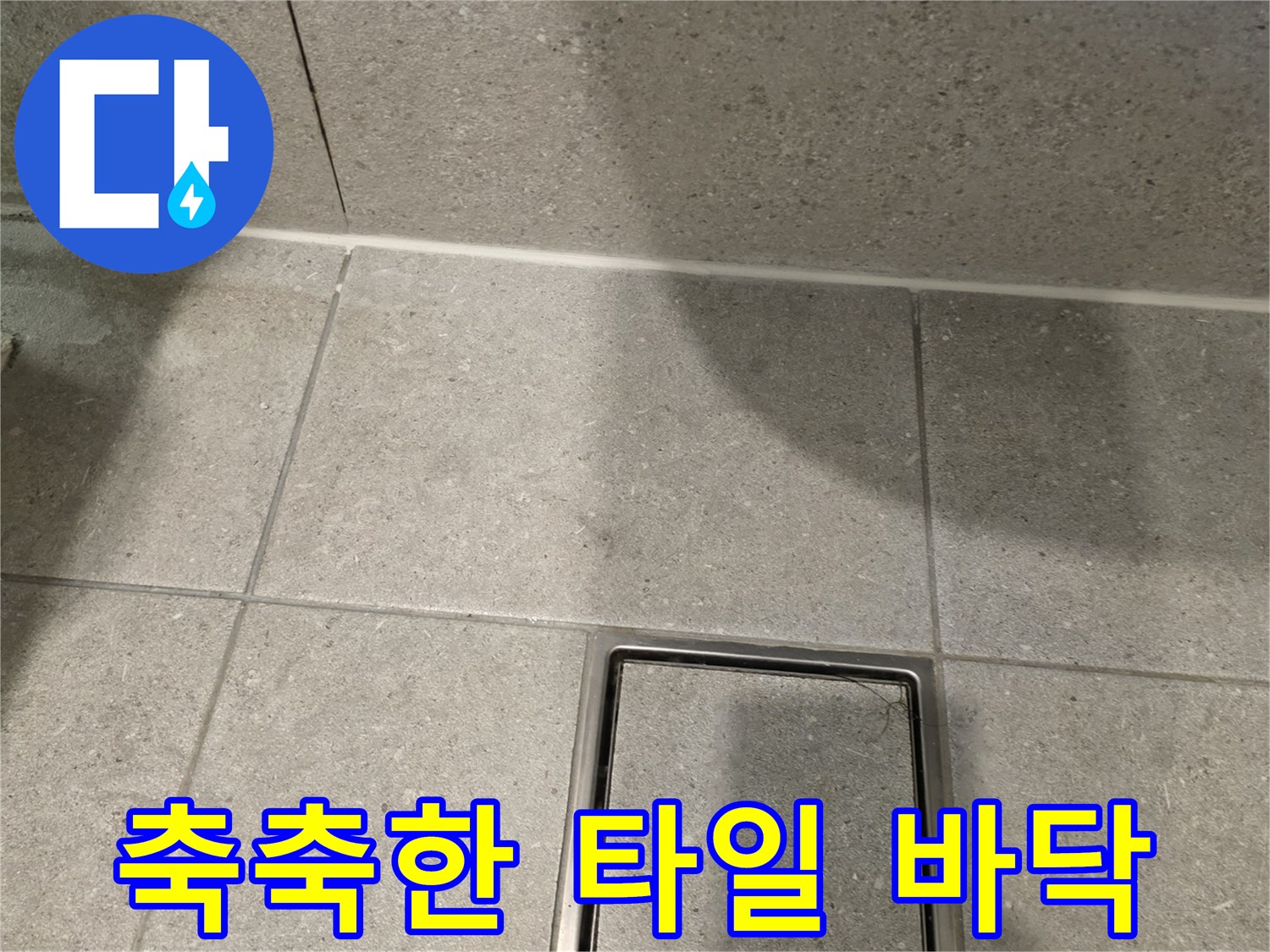습기가 감지되는 욕실 타일과 배수구 주변의 상세 사진입니다.