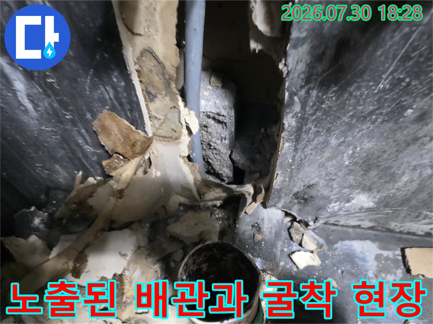 파손된 마감재를 제거하고 노출된 배관을 점검하는 누수 공사 현장