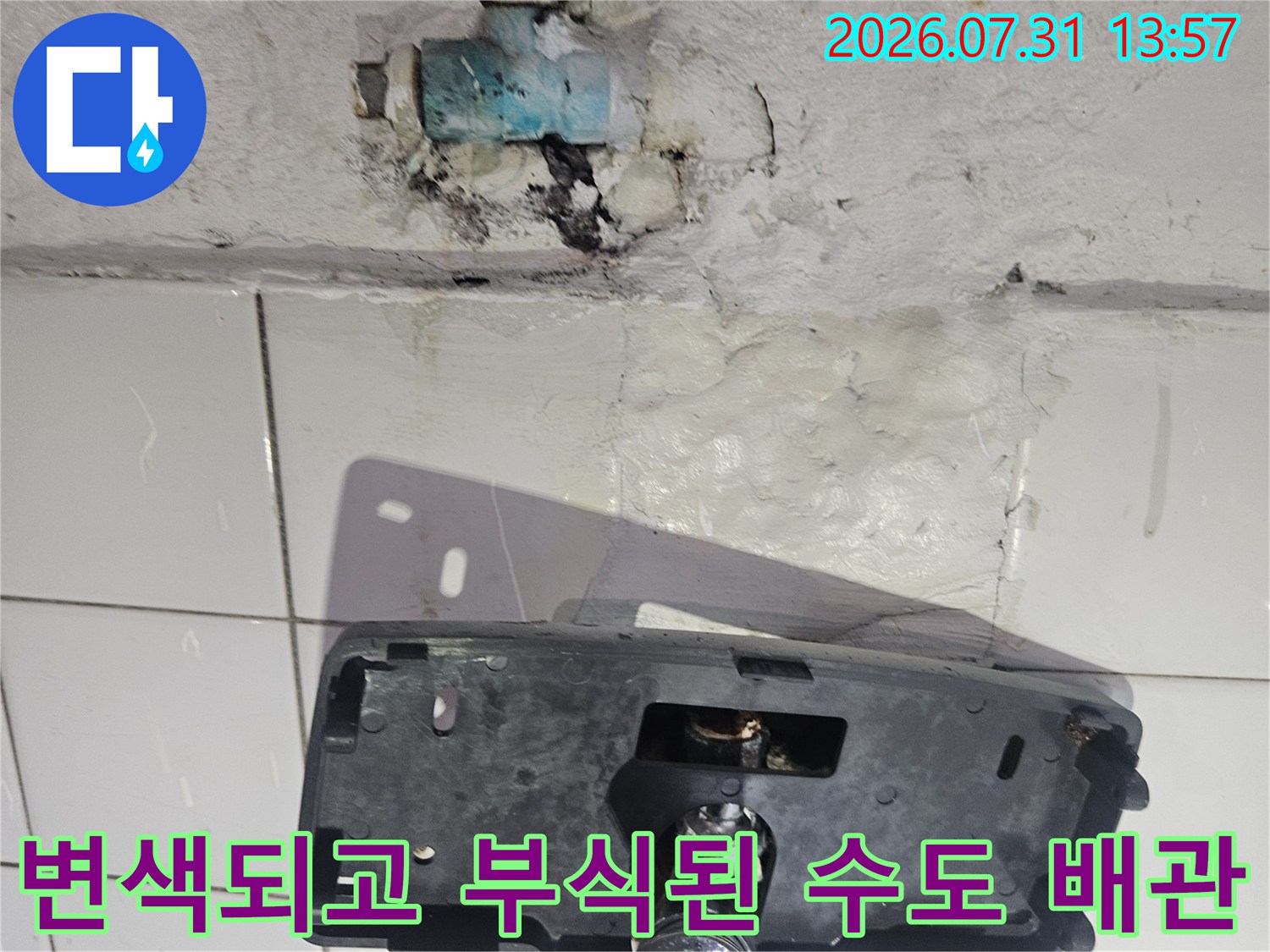 벽면 노출부의 부식된 밸브와 누수가 발생한 배관 연결 위치 설명