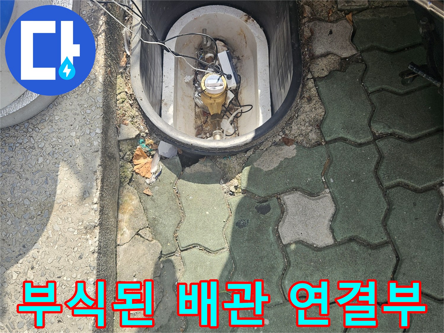 보도블록 사이 노출된 금속 배관의 녹슨 상태와 오염된 주변 환경