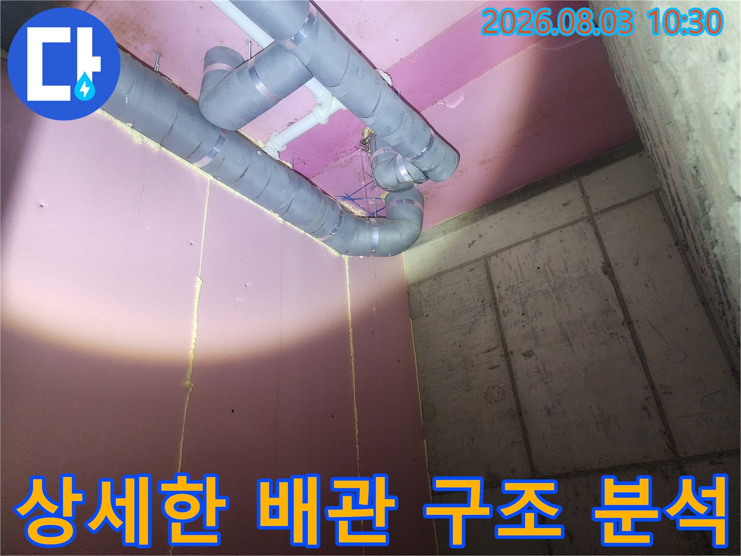 분홍색 벽면을 배경으로 한 복잡한 배관 연결부의 정밀 점검 사진
