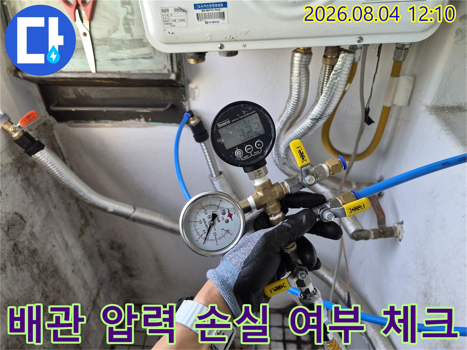 전문가가 장갑을 끼고 배관 연결부에 게이지를 부착하여 정밀하게 점검하는 장면