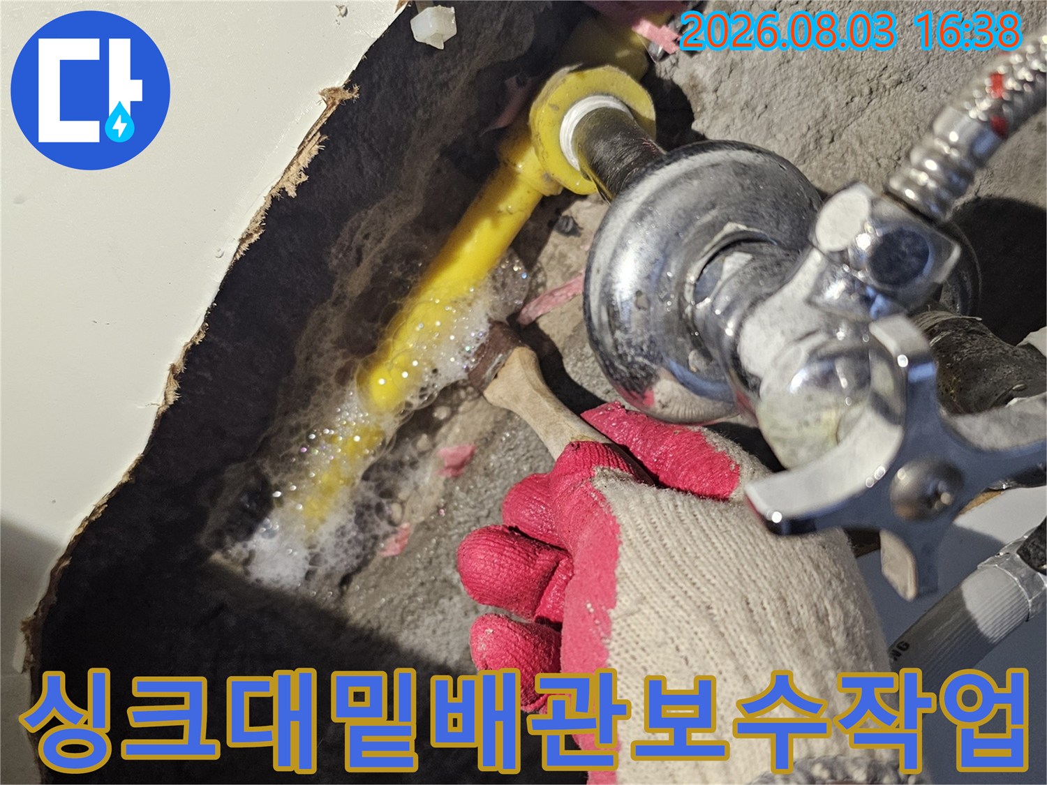 노출된 싱크대 아래 노란색 배관과 연결 부위를 정밀하게 진찰하는 모습