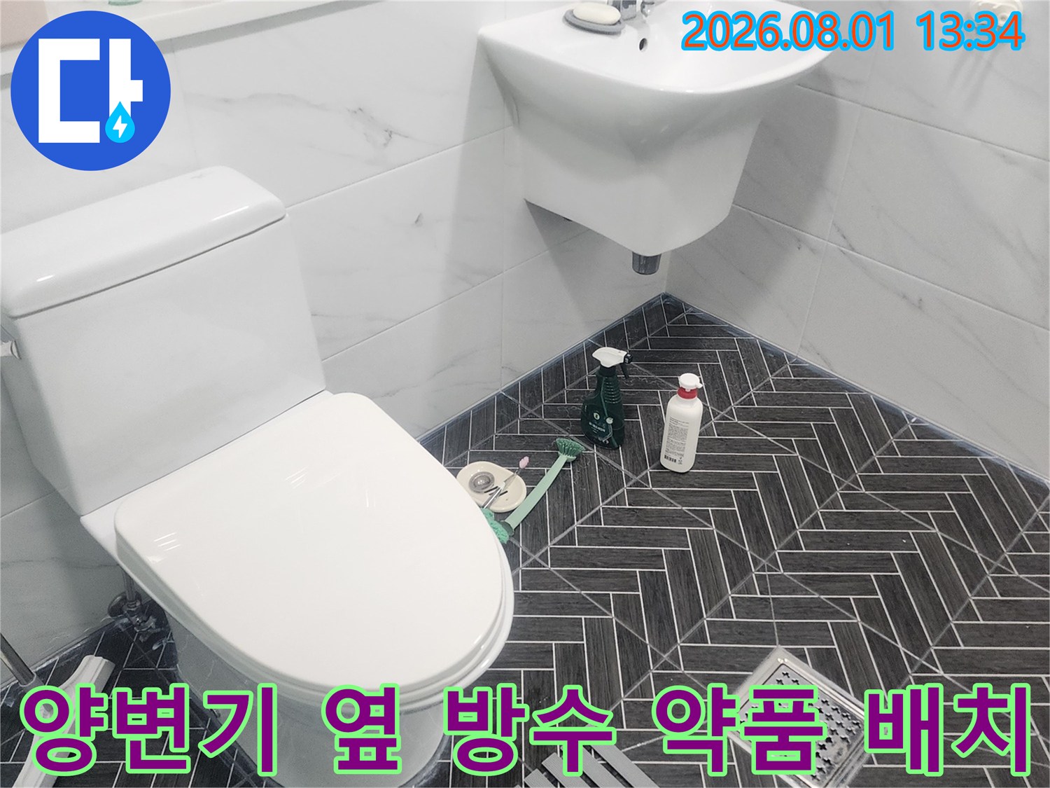 양변기와 세면대 주변에 배치된 화장실 방수용 코팅제와 공구들