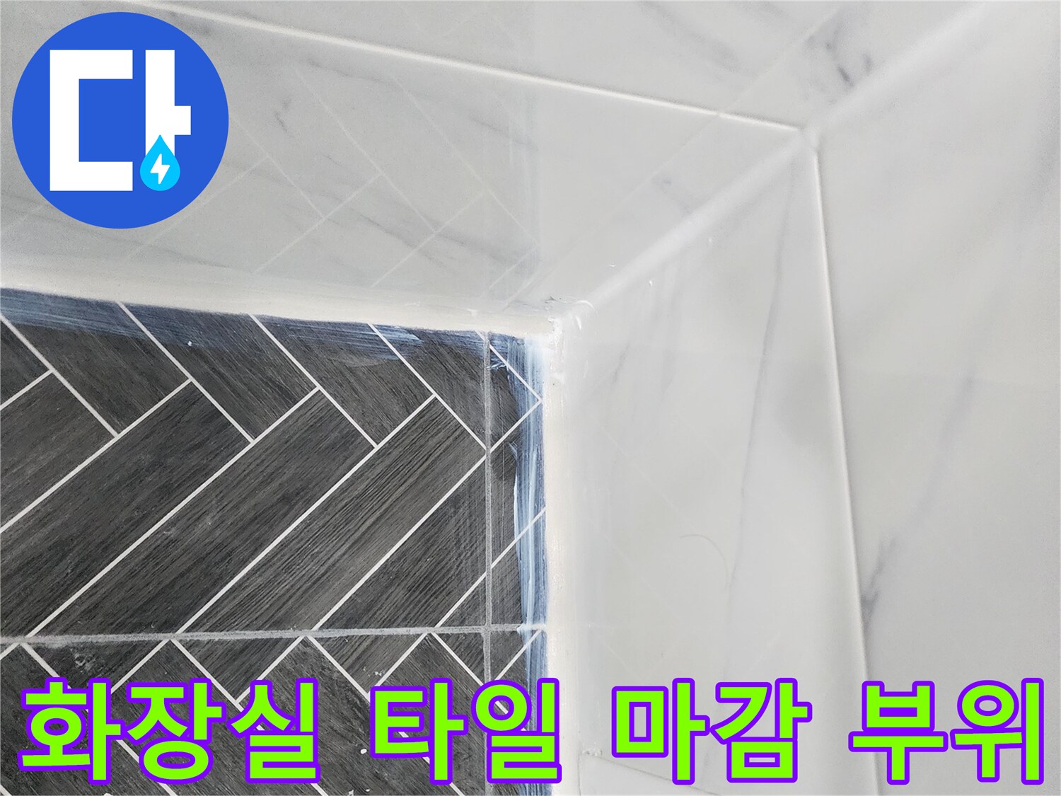 어두운 색상의 헤링본 타일과 흰색 벽면 타일의 경계선