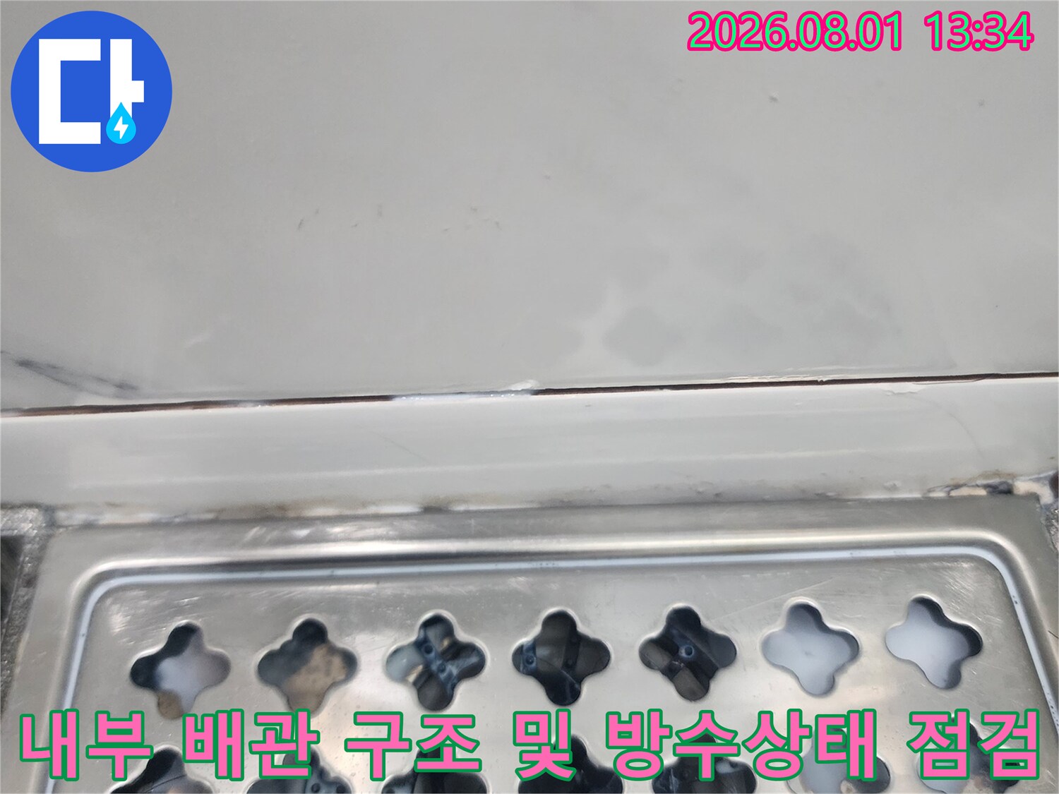 화장실 천장 내부의 배관과 마감면을 대조하며 누수 유입 경로를 파악하는 모습