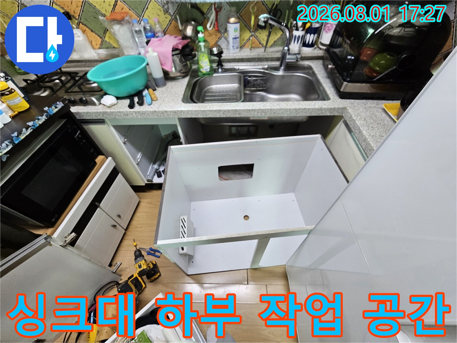 누수 지점을-찾기 위해 싱크대 아래를 비워둔 작업 현장입니다.
