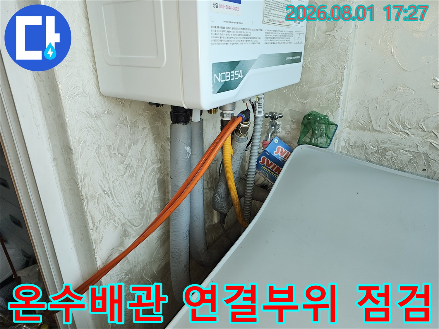 싱크대 하단에 위치한 온수 배관과 가스 계량기 주변의 배관 상태를 확인하는 모습