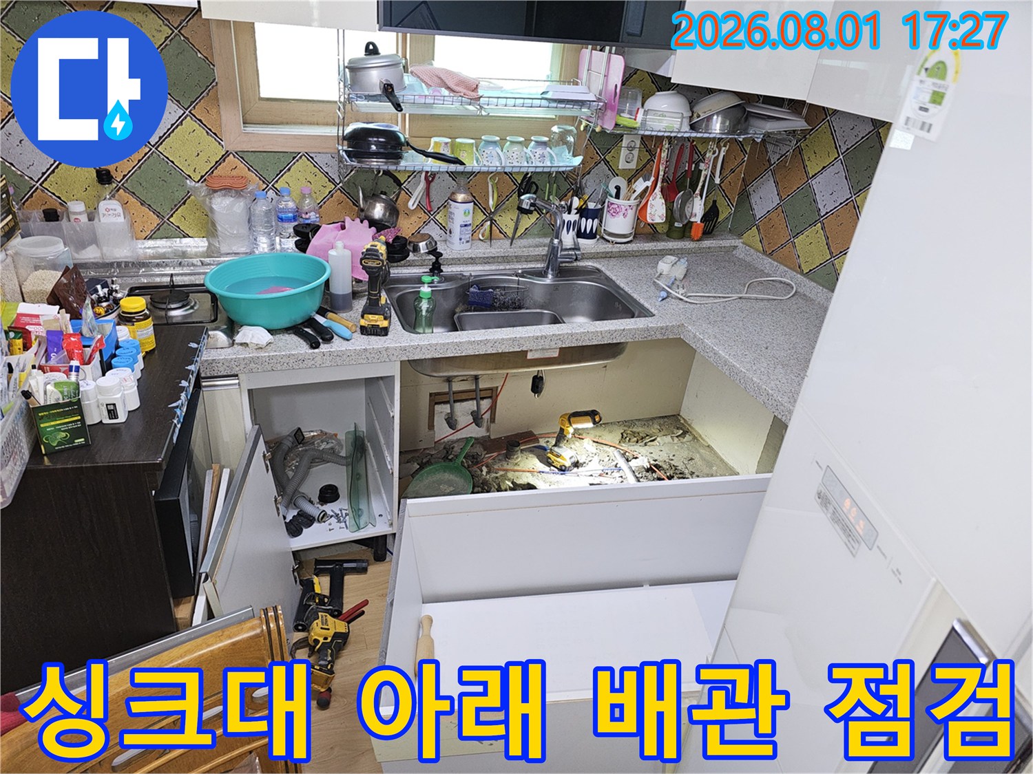 싱크대 하부 공간에서 굴착을 통해 드러난 수도 및 온수 배관들