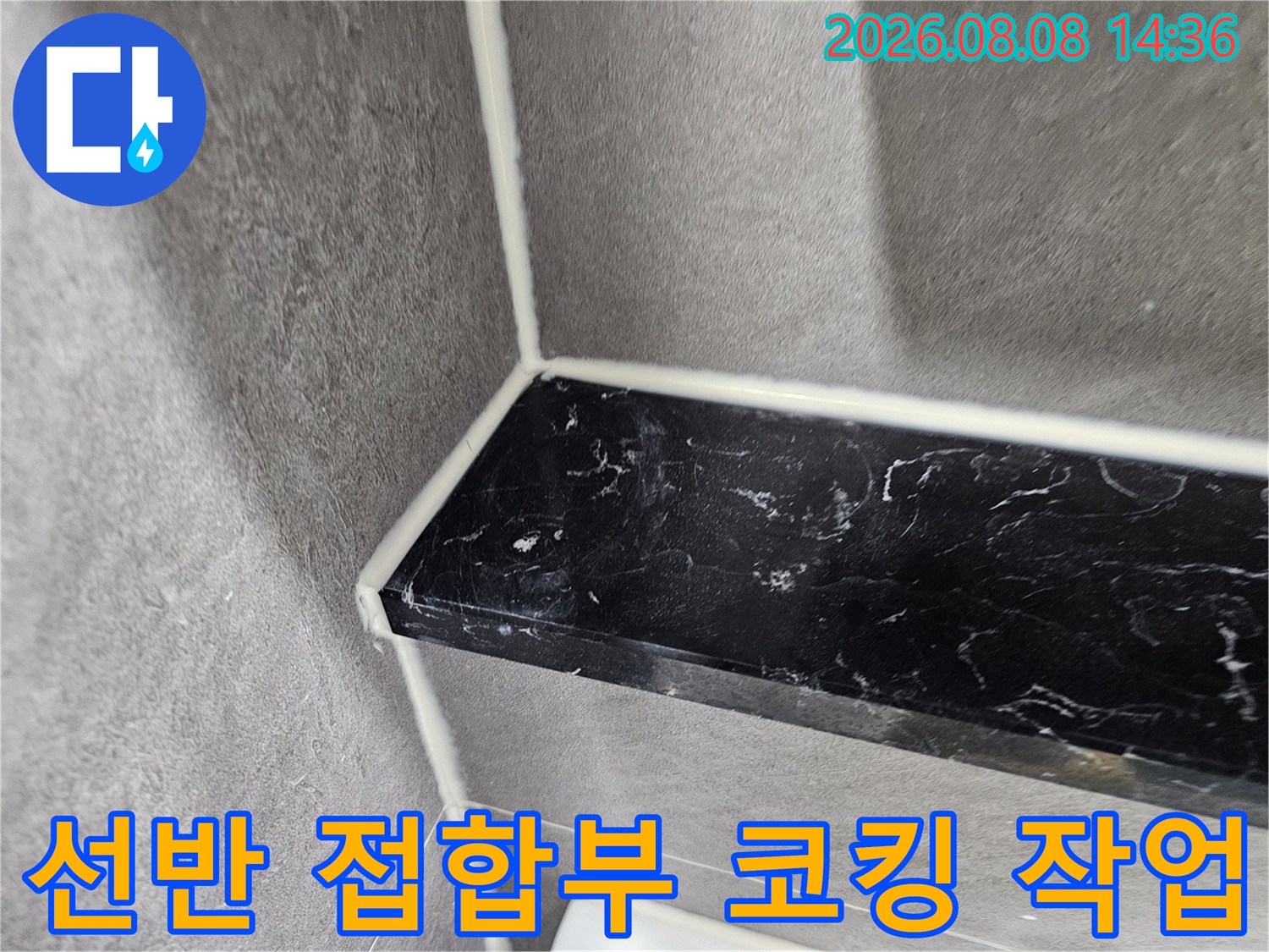 회색 벽면 타일과 검은색 선반의 경계 실리콘 마감 상세