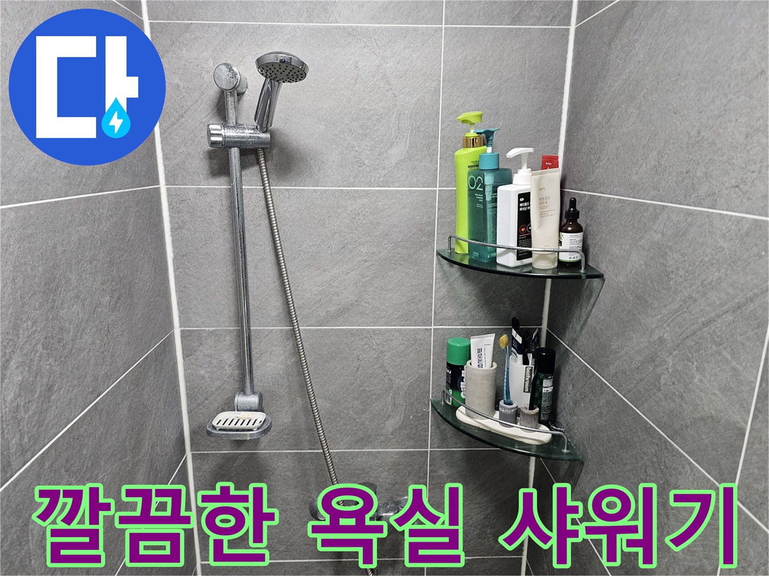회색 타일 벽면에 설치된 샤워기 헤드와 수전의 모습입니다.