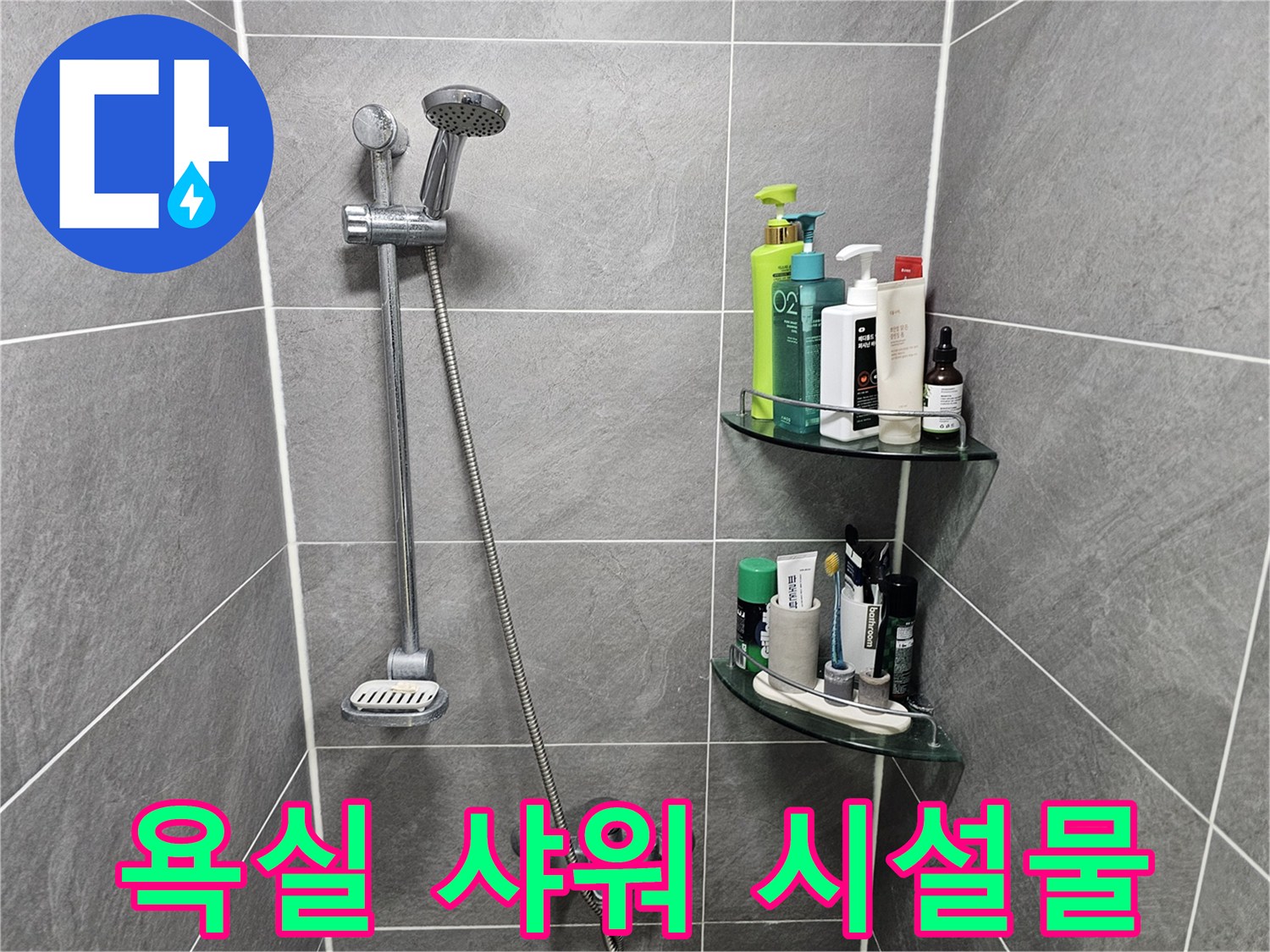 회색 타일 벽에 설치된 샤워 헤드와 세면 용품 선반