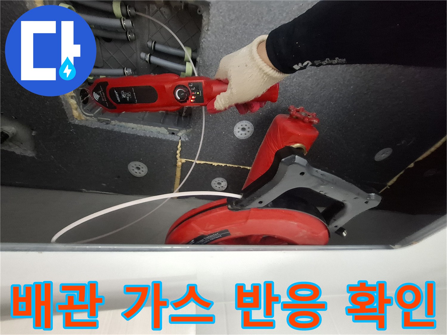 천장 배관 사이로 가스 탐지기를 넣어 누출을 찾는 작업 현장