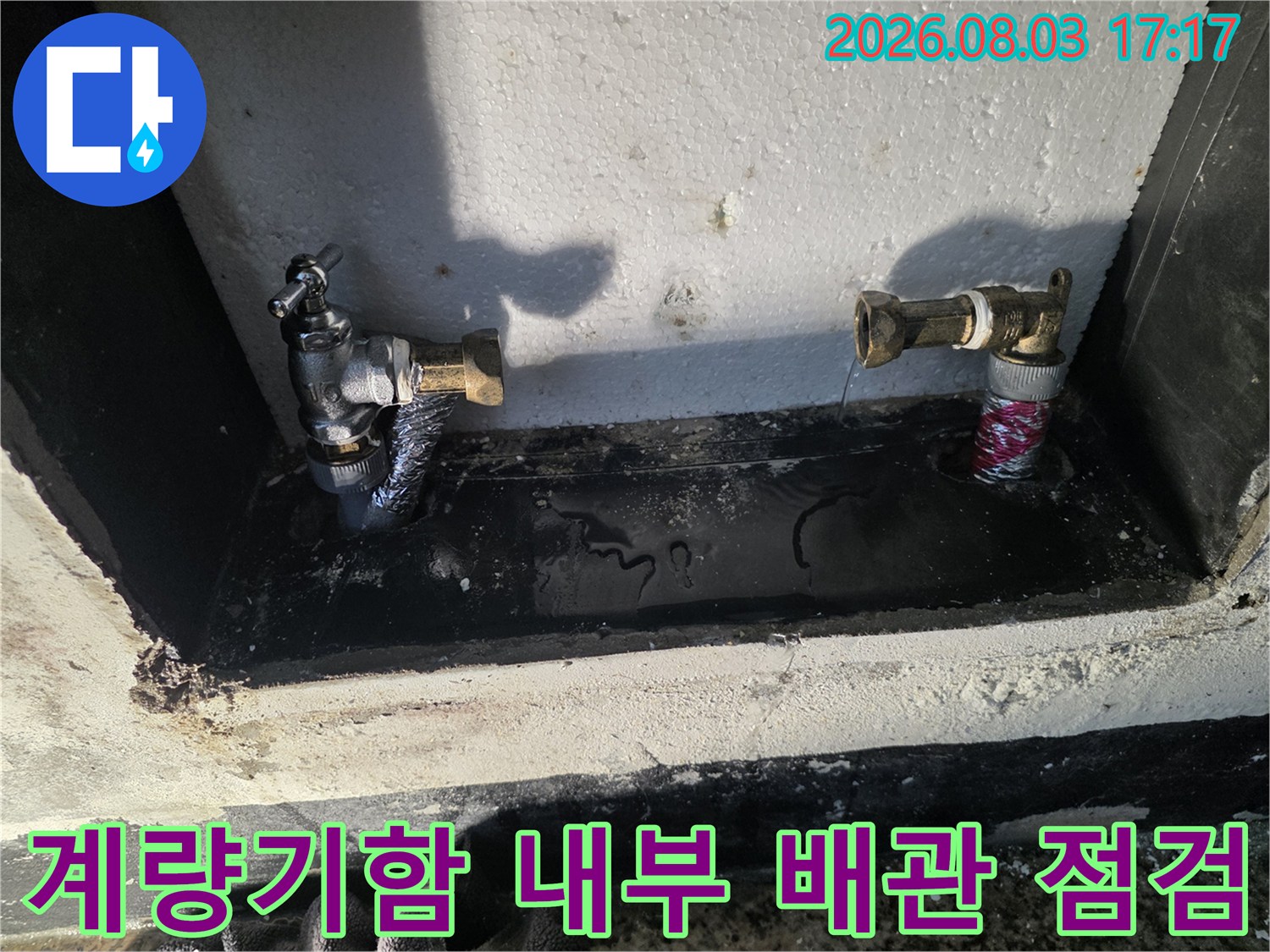 계량기함 내부에 위치한 노출 배관과 연결 부위의 상태를 점검하는 모습