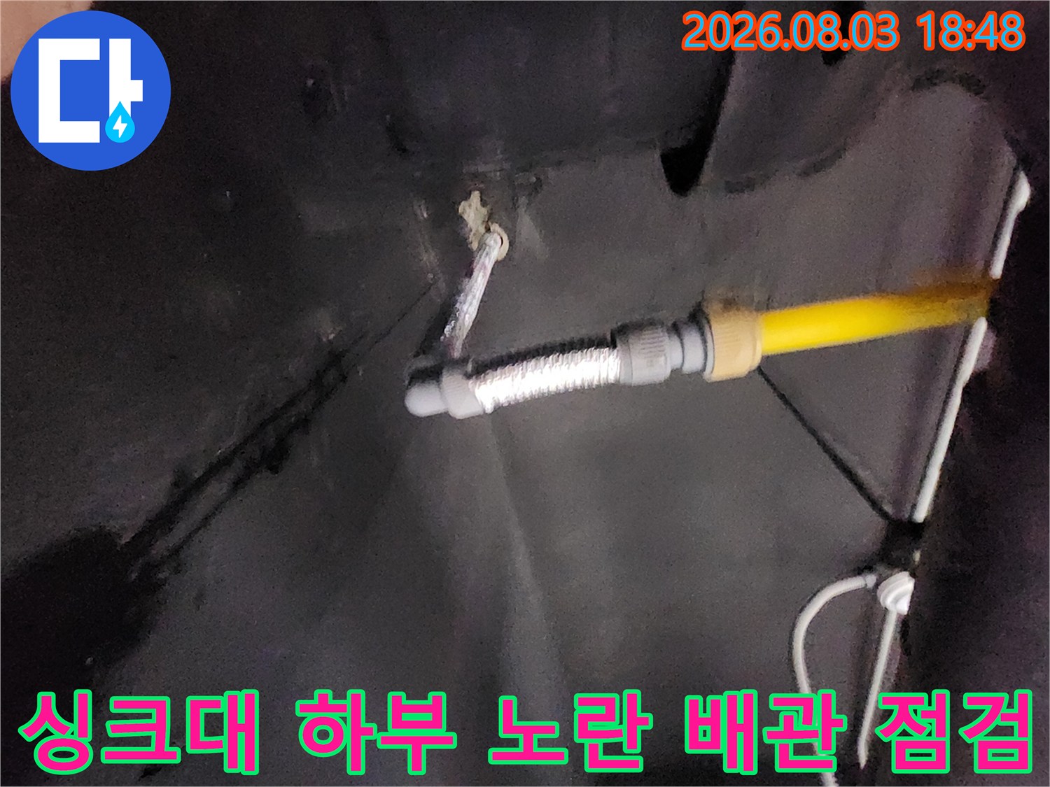 싱크대 밑에 위치한 노란색 배관과 주름관 연결 부위 점검 사진