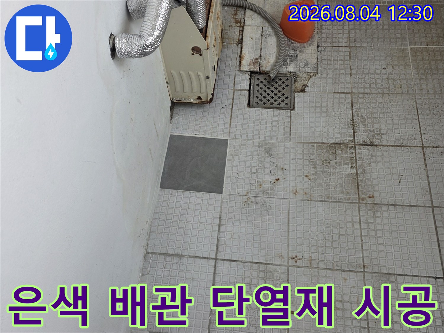 단열재로 감싸진 노출 배관과 타일 벽면의 누수 수리 현장