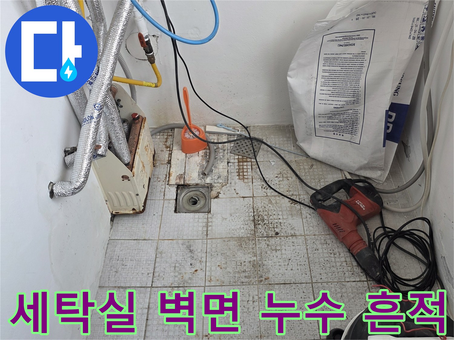 습기에 의해 변색된 세탁실 타일과 노출된 배관의 모습입니다.