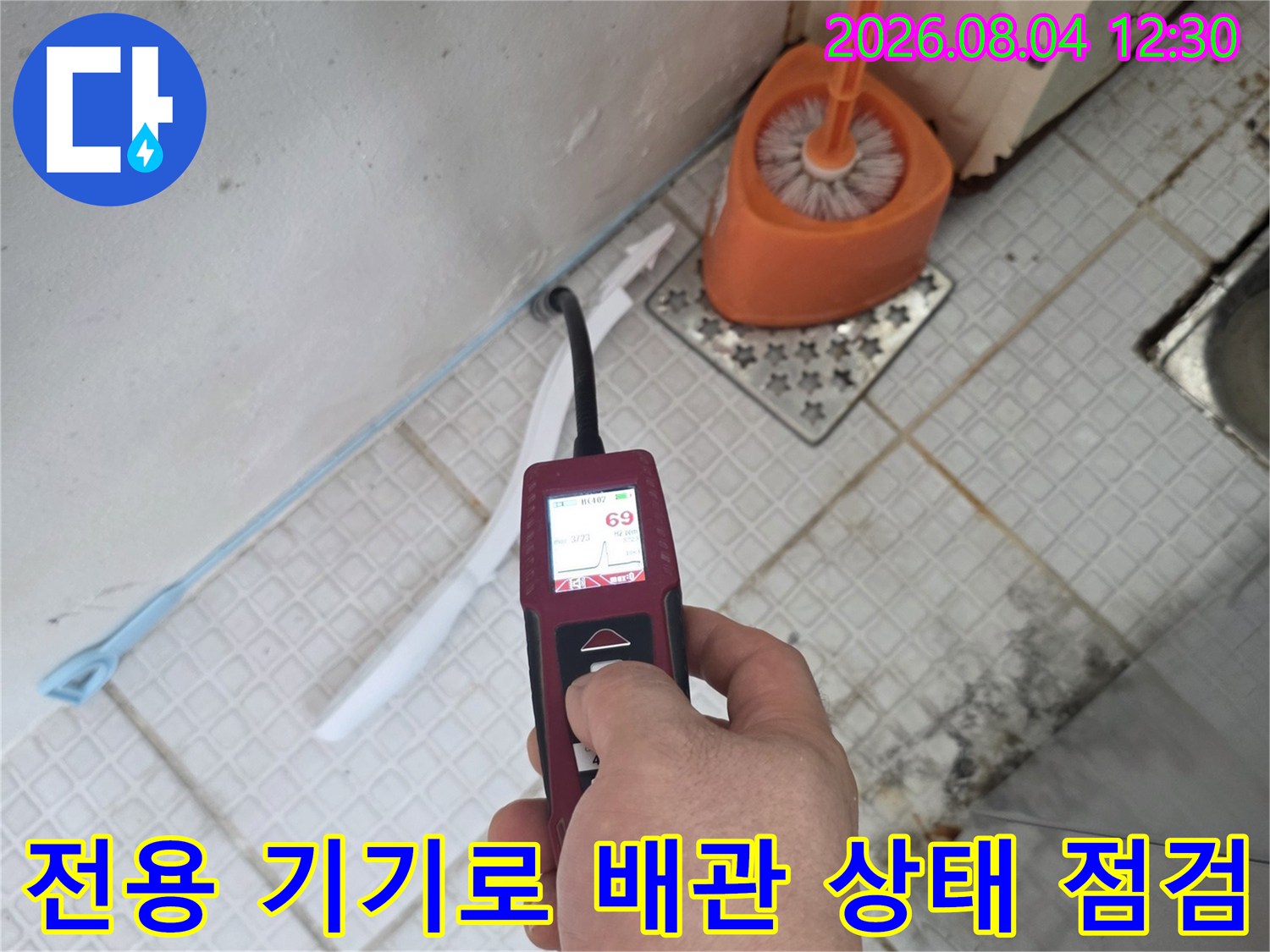 특수 탐지 장비를 사용하여 노출된 배관의 누수 여부를 상세히 측정하는 모습입니다.