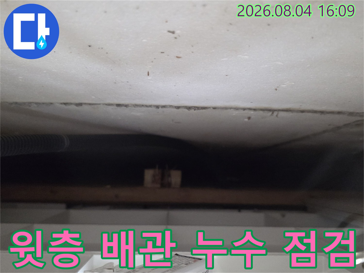 어두운 천장 내부 공간에서 노출된 배관을 정밀하게 검사하는 모습
