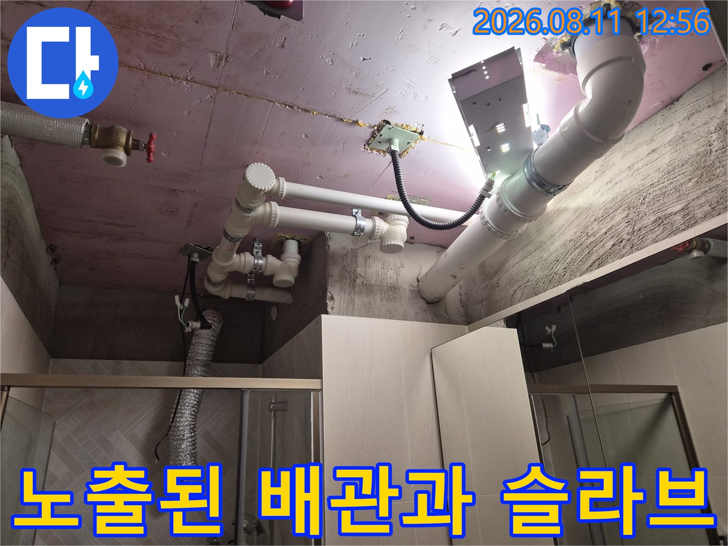 분홍색 천장 슬라브에 설치된 하얀색 PVC 배관의 연결 부위