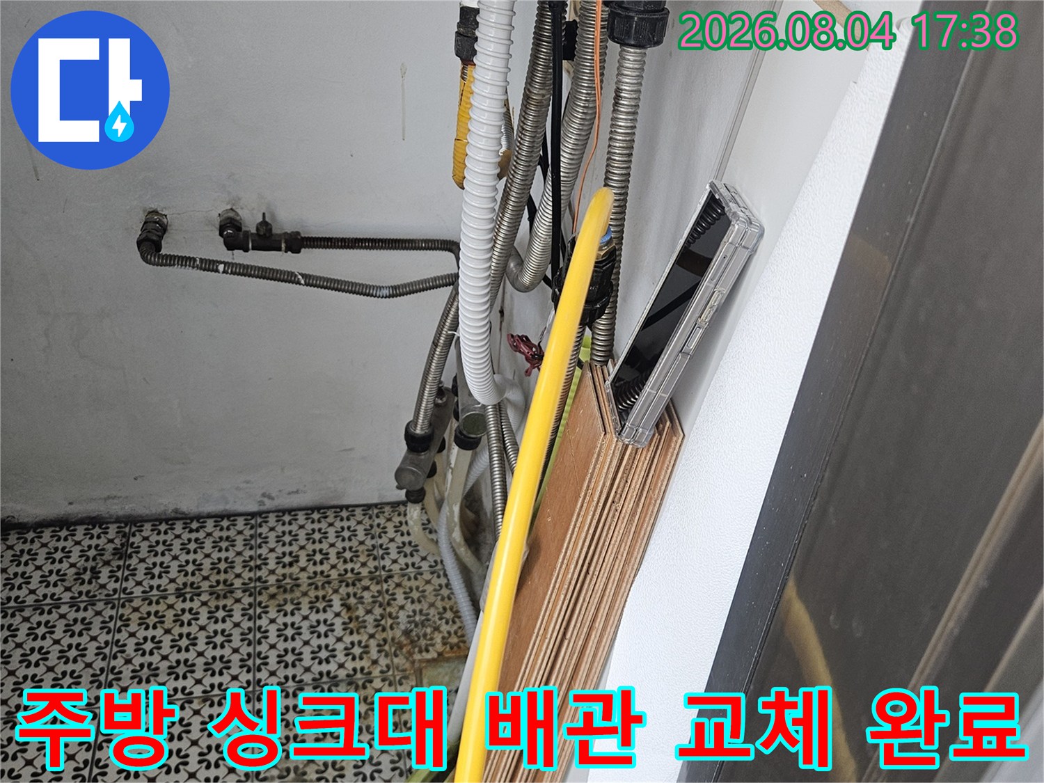 싱크대 아래쪽 노란색 보온재로 감싼 온수 배관을 수리하는 상세 사진