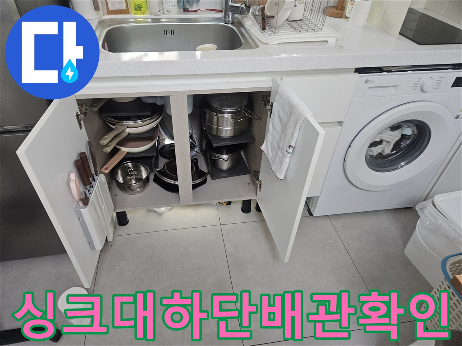 싱크대 하부장 내부의 배관과 주변 환경을 촬영한 사진
