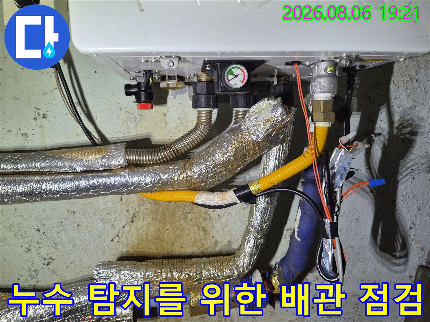 노란색과 파란색 보호재로 감싸진 보일러 배관의 상세 점검 장면