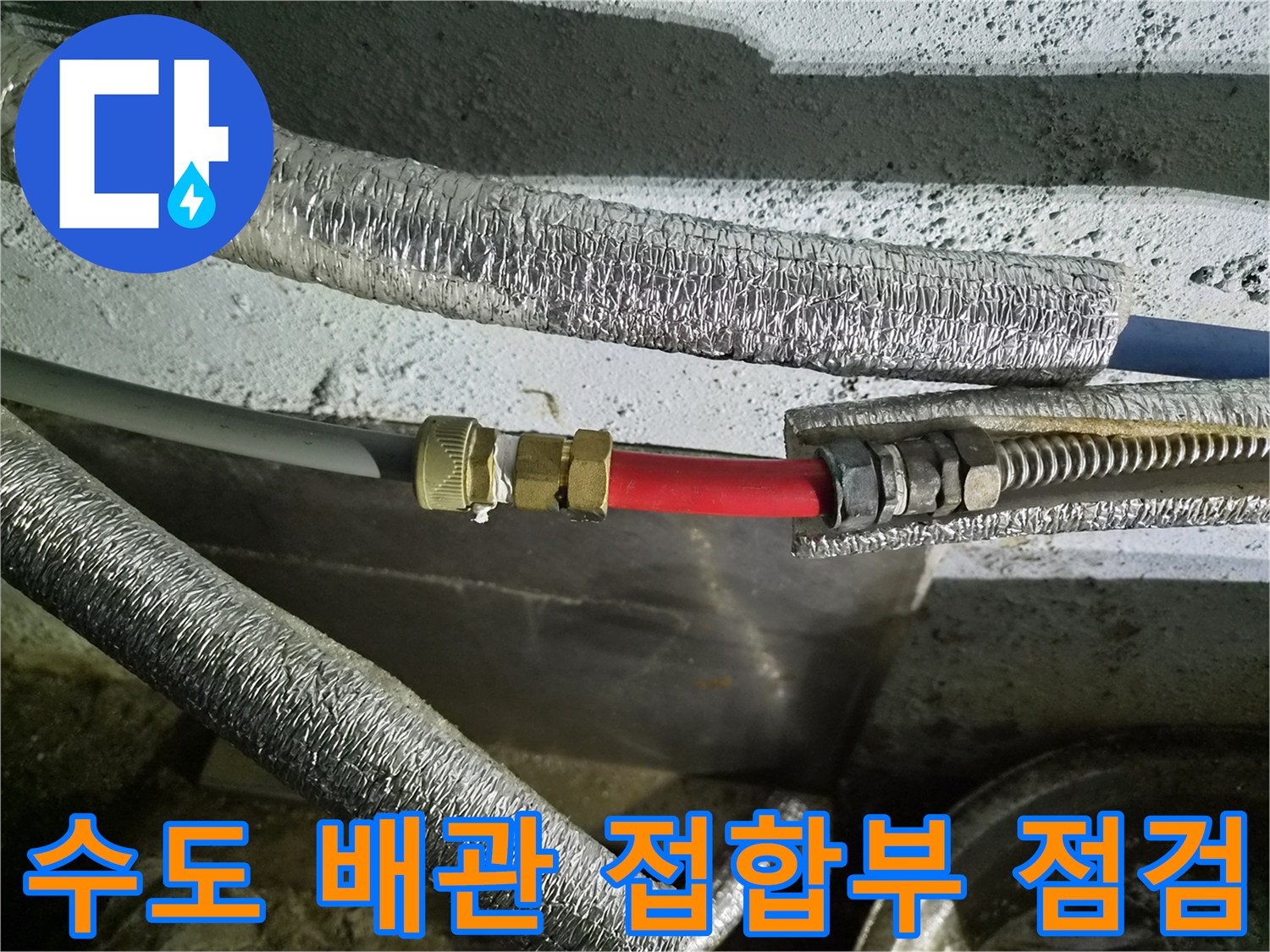 은박 보온재와 붉은색 호스가 교차하는 배관 연결 부위의 근접 사진