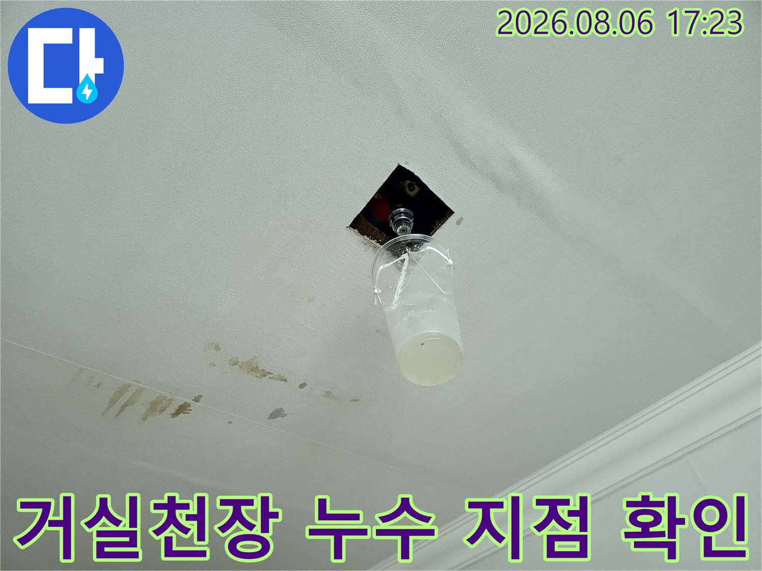 거실 천장의 배관 연결 부위에서 발생한 물자국과 노출된 전선 보호용 튜브가 보이는 현장 사진
