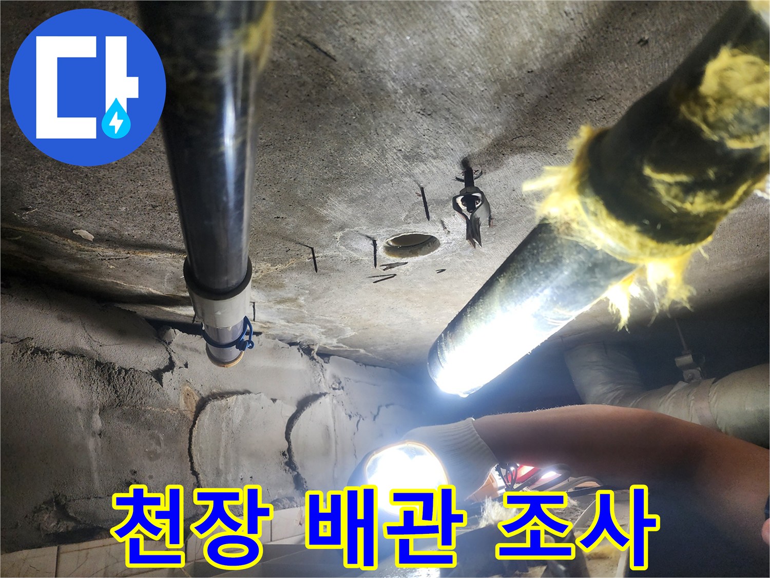 손전등으로 비춘-배관 주변의 오염된 천장 마감 부위