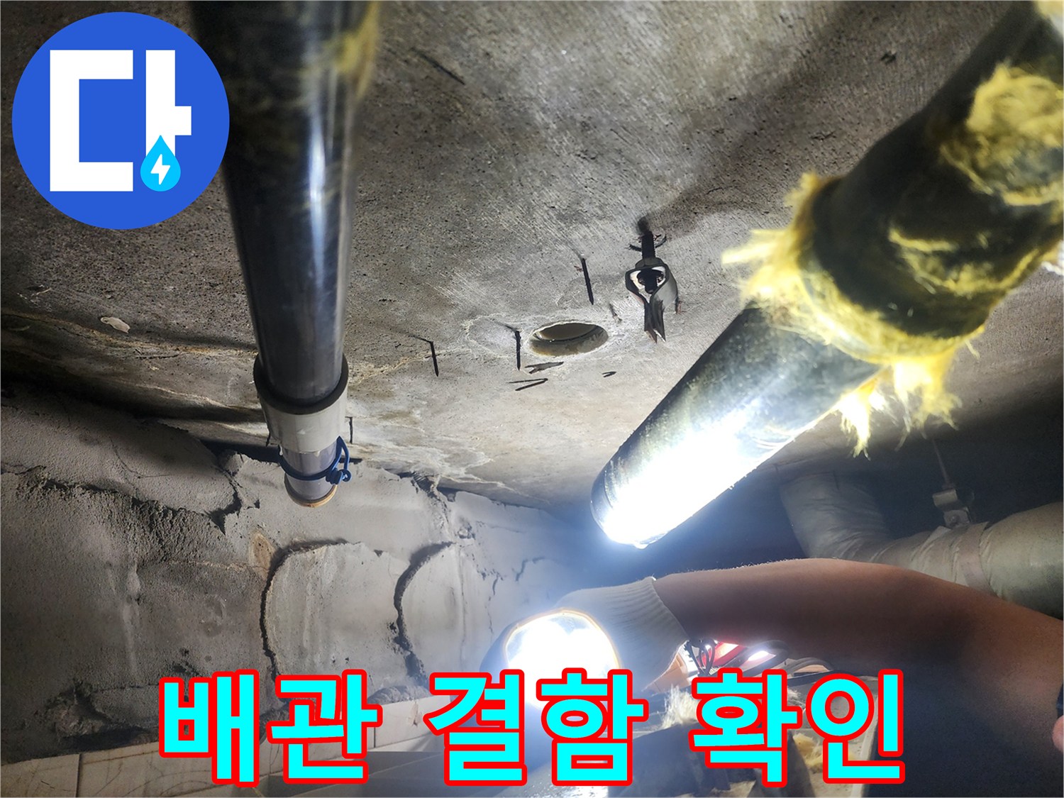 어두운 천장 내부를-밝게 비추며 진행하는 배관 점검 작업