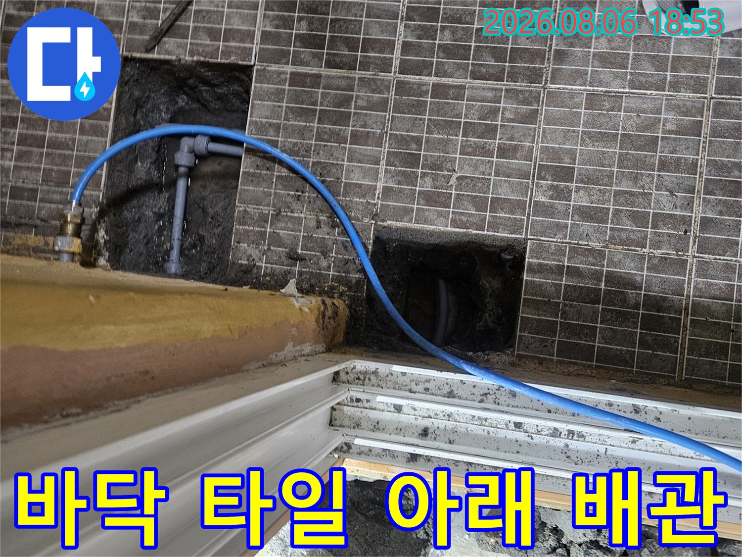 타일을 제거하고 콘크리트를 파내어 드러난 매립 배층 배관의 모습입니다.