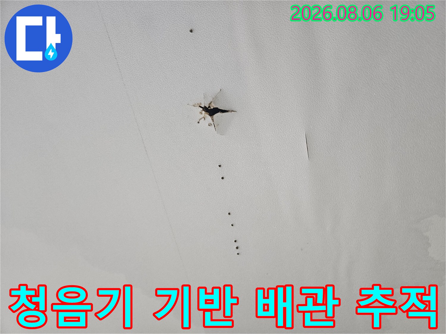 청음 탐지기를 사용하여 화장실 내 매립된 배관의 파손 지점을 세심하게 찾아내는 과정