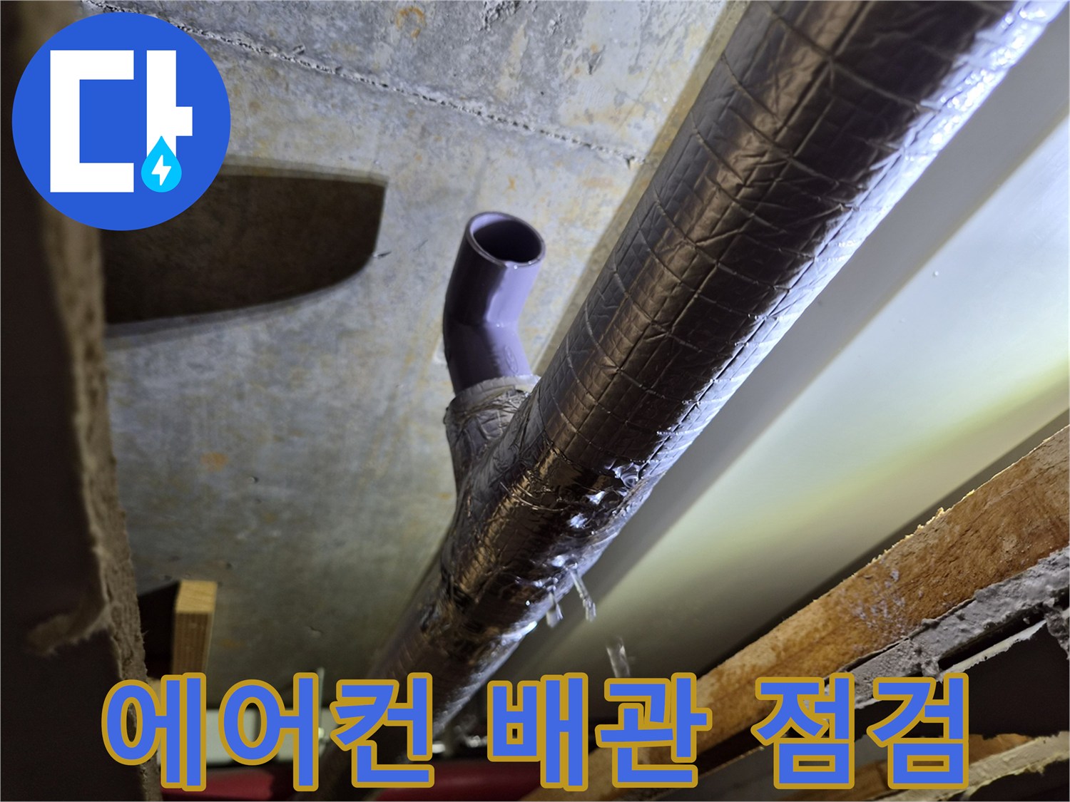 보온재로 감싸진-에어컨 드레인 배관의 상태를 확인하는 모습